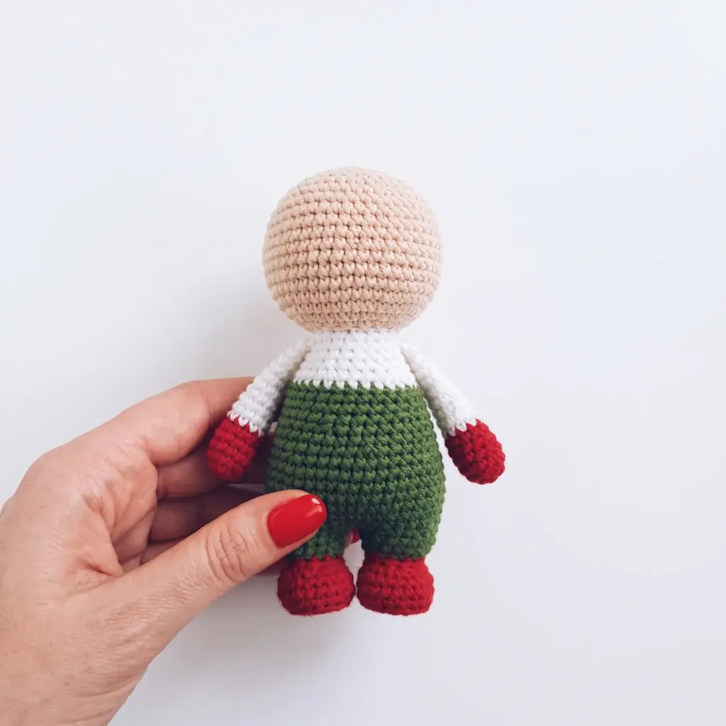 Crocheted gnome body with arms attached, before the face, beard, and hat