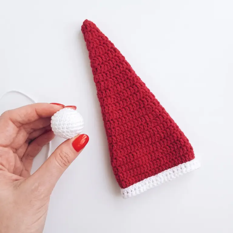 Finished red and white crochet hat and pom-pom, ready to be sewn together