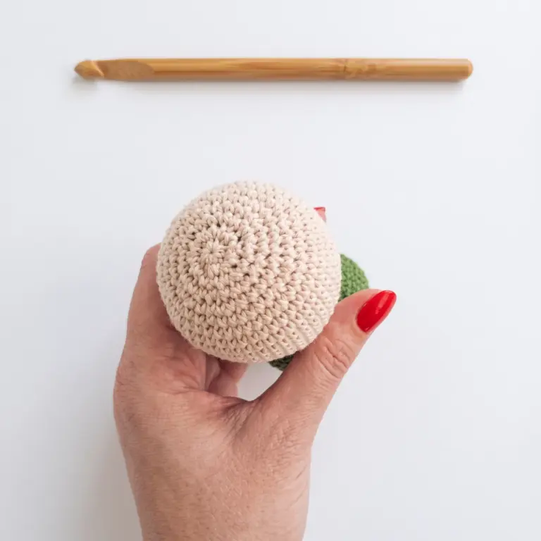 Back view of the finished beige crochet gnome head before the face is added