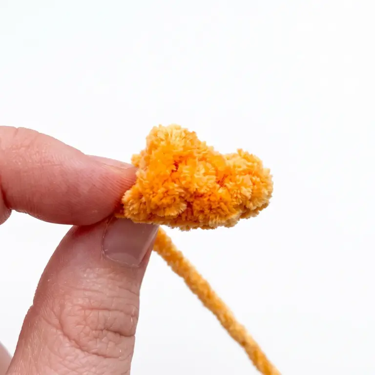 Small crocheted carrot nose piece for the snowman amigurumi before attaching